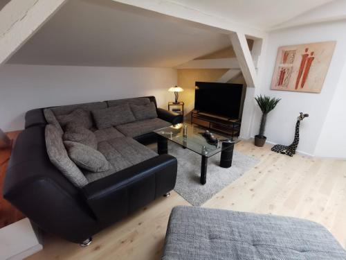 a living room with a black couch and a tv at Ferienwohnung Alte Feuerwehr in Ueckermünde