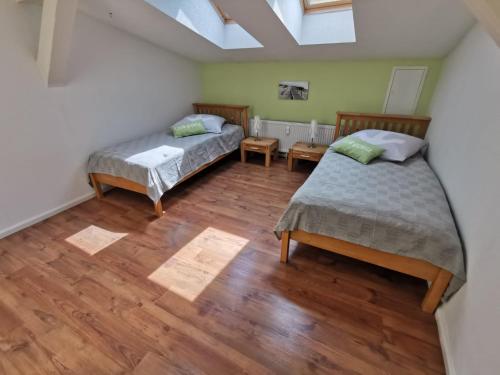 two beds in a room with wooden floors at Ferienwohnung Alte Feuerwehr in Ueckermünde