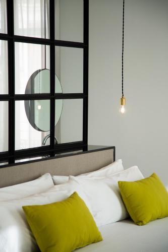 a bed with two yellow pillows and a window at MYR Marqués House in Valencia