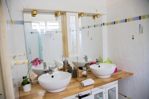 a bathroom with two sinks and a mirror at Maison de 4 chambres avec vue sur la mer jacuzzi et jardin clos a Sainte Rose a 5 km de la plage in Sainte-Rose