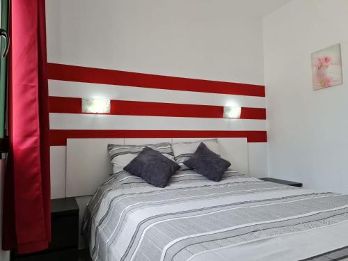 een slaapkamer met een bed met een rood en wit hoofdeinde bij Maspalomas Lago One Bedroom Bungalow 39 in Maspalomas