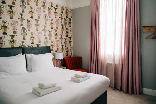 a bedroom with a bed with towels on it at Bryn Berwyn Country House Tresaith in Penbryn