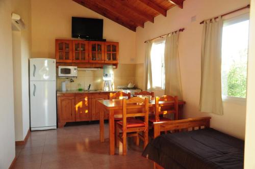 Corazon de Montaña في ميرلو: مطبخ وغرفة طعام مع طاولة وثلاجة