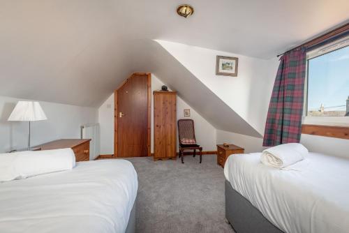 a bedroom with two beds and a window at The Cooperage - 2 Bedroom, 2 Bathroom with Garden in Crail