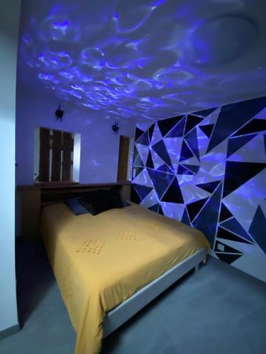 une chambre avec un lit avec un plafond bleu dans l'établissement Au cœur du Sénéchal, à Marquise