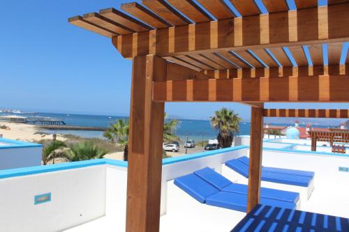 ラ・オリーバにあるVilla Delhi by Privilege Bayの木製パーゴラの下に青い椅子が置かれたプール