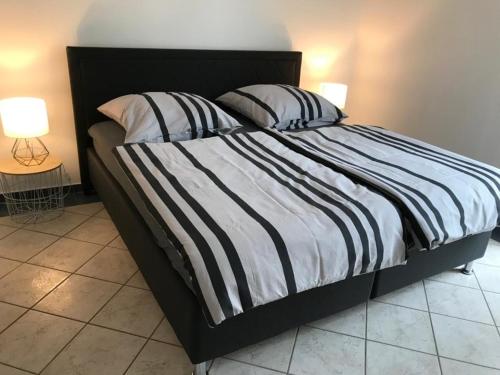 ein Bett mit einer schwarzen und weißen gestreiften Bettdecke und Kissen in der Unterkunft Blue House Mosel in Piesport