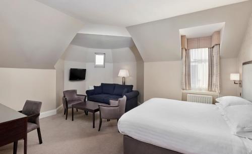 sypialnia z łóżkiem, biurkiem i kanapą w obiekcie Leonardo Edinburgh City w Edynburgu