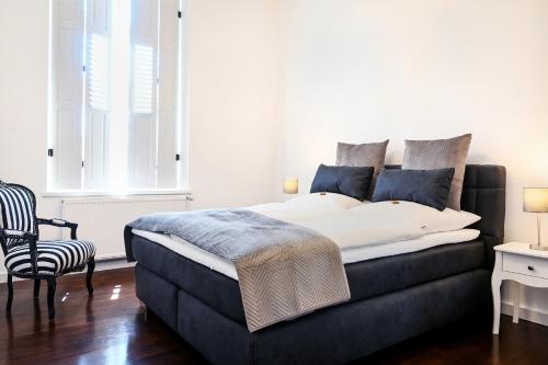 - une chambre avec un grand lit et une chaise dans l'établissement Insel-Apartment im Herrenhaus Rheinblick, à Xanten