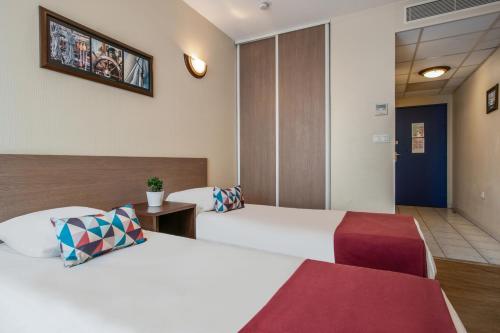 a hotel room with two beds in a room at Appart'City Classic Nîmes in Nîmes