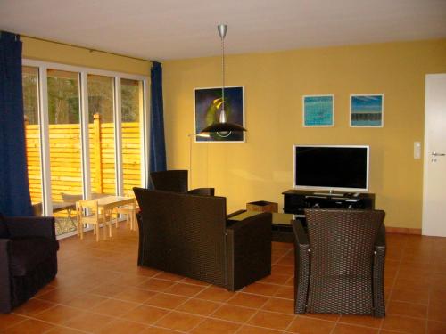 a living room with a flat screen tv and chairs at Wilja in Friedenstal