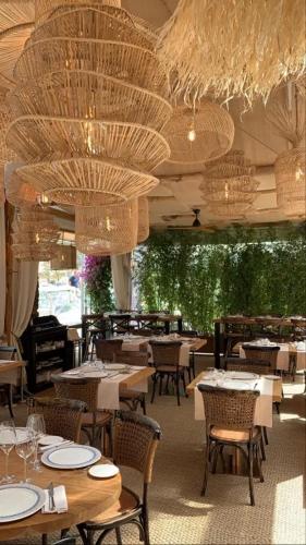 un restaurant avec des tables, des chaises et des lustres dans l'établissement Hotel la Caravelle, à Bonifacio
