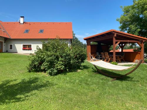 a hammock in a yard next to a house at Chalupa Jako doma in Nová Bystřice
