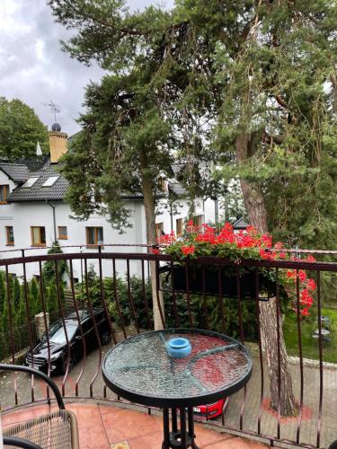 a table on the balcony of a house with flowers at Willa 4 Pory Roku & Uznam in Świnoujście