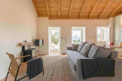un soggiorno con divano e TV di Walnut Cottage - Cosiness between hills and sea. a Nafarros