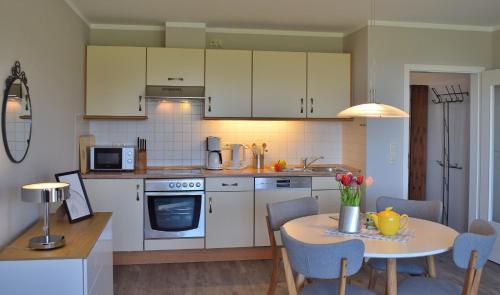 a kitchen with a table and a table and chairs at Fehmarnstrand 77 Whg 5 in Staberdorf