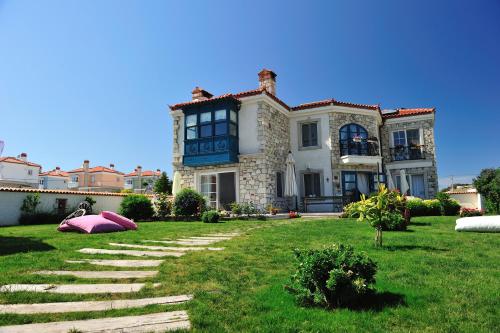 una gran casa con un gran patio con un campo de hierba en Alaçatı Sultan Konak Butik Otel ℳℛ Luxury Concept en Alacati