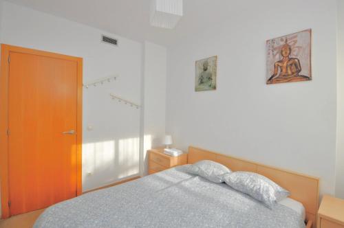 リョレート・デ・マルにあるApartment Tetianaのベッドルーム1室(ベッド1台付)、木製のドア
