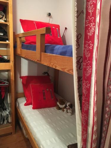 two bunk beds in a room with red pillows at Val Thorens - Confortable Appartement 4 personnes in Val Thorens