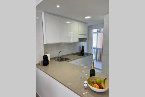 eine Küche mit einer Schale Obst und einer Flasche Wein in der Unterkunft Holiday apartment in Salou