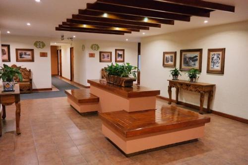 a large room with tables and potted plants in it at Plaza Uruapan Hotel  in Uruapan del Progreso