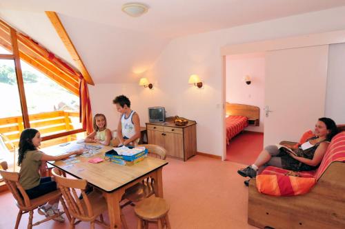 a group of people sitting around a table in a room at Résidence Goélia - Le Rond Point des Pistes in Saint-François-Longchamp