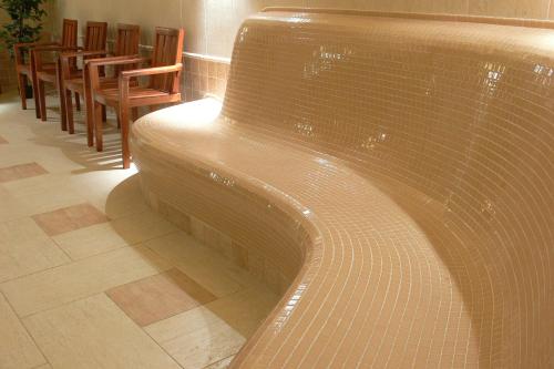 a large pool in a room with tables and chairs at Öreg Miskolcz Hotel in Miskolc