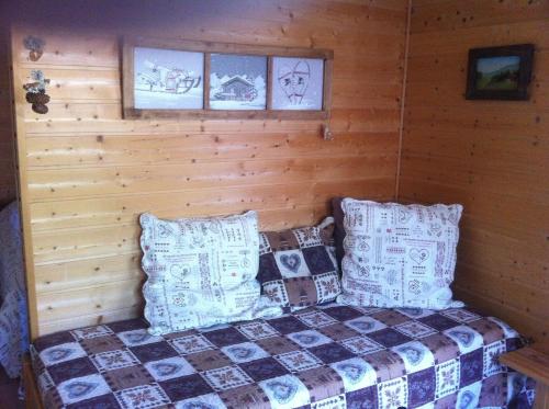 ein Schlafzimmer mit einem Bett in einem Blockhaus in der Unterkunft Les Gîtes du Cairn in Vernamiège