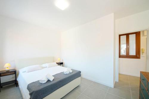 a bedroom with a white bed with two towels at DolceVita Apartments N. 491 Biennale in Venice