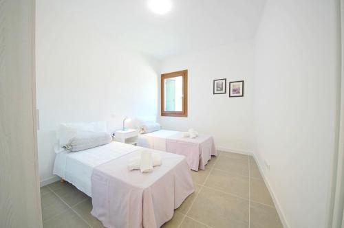 a white room with two beds and two tables at DolceVita Apartments N. 491 Biennale in Venice