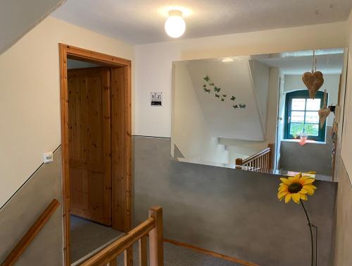 a hallway with a staircase with a sunflower on the wall at Haus Grüne Idylle in Bannewitz