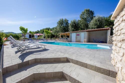 une terrasse avec une piscine et des chaises longues dans l'établissement Les Prairies de l'Encrême, à Céreste