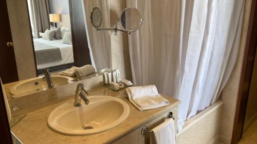 a bathroom with a sink and a mirror at Santarem Hotel in Santarém