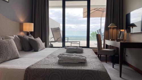 a hotel room with a bed with a desk and a desk at Santarem Hotel in Santarém