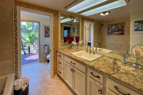 a bathroom with a sink and a large mirror at Colorful El Cajon Gem Deck, Garden and Valley Views in El Cajon