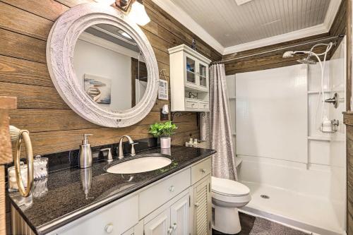 a bathroom with a sink and a mirror and a toilet at Waterfront Gem on Lake Sinclair with Boat Dock! in Resseaus Crossroads