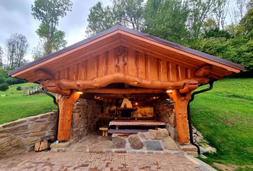 a wooden pavilion with a picnic table in a field at Penzion U Sovy in Dolný Kubín