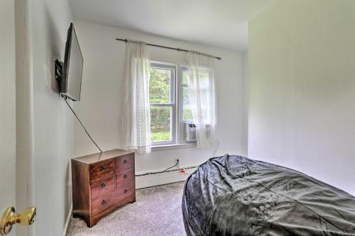 a bedroom with a bed and a dresser and a window at Spacious Sullivan County House with Fire Pit in Hurleyville