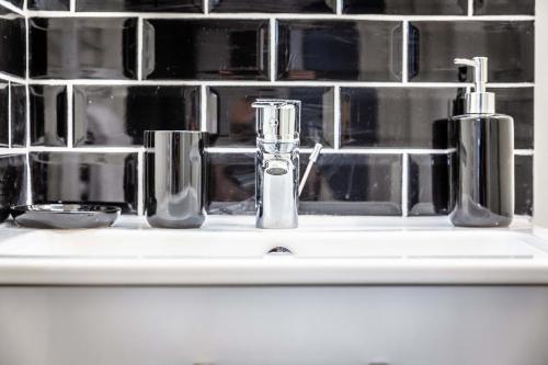 - un lavabo dans la salle de bains avec deux distributeurs de savon dans l'établissement Le Valet de Pique - 1 chambre, à Brive-la-Gaillarde