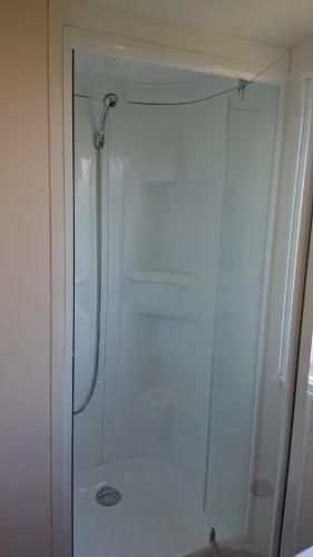 une douche avec une porte vitrée dans une salle de bain dans l'établissement Camping Le Montourey, à Fréjus