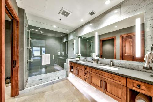 y baño con ducha, 2 lavabos y bañera. en Luxury Two Bedroom Residence steps from Heavenly Village condo, en South Lake Tahoe
