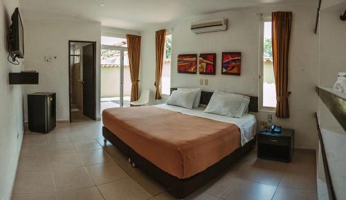 ein Schlafzimmer mit einem großen Bett in einem Zimmer in der Unterkunft Hotel Paloverde Villas Campestres in Villavicencio