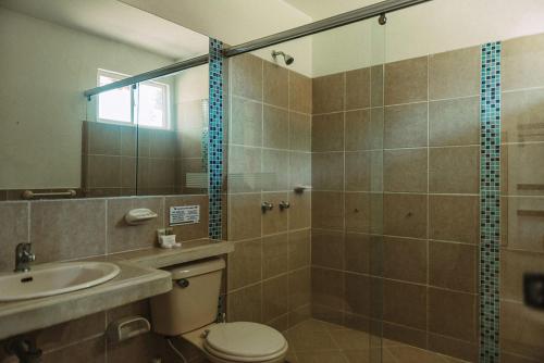 uma casa de banho com um WC, um lavatório e um chuveiro em Hotel Paloverde Villas Campestres em Villavicencio