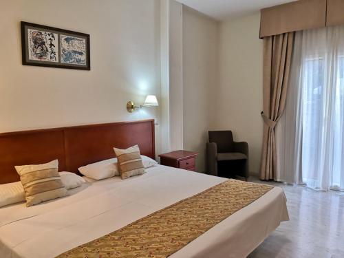 a hotel room with a large bed and a window at La Luna Blanca in Torremolinos