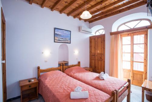 a bedroom with two beds and a window at Florance Apartments & Rooms in Mikonos
