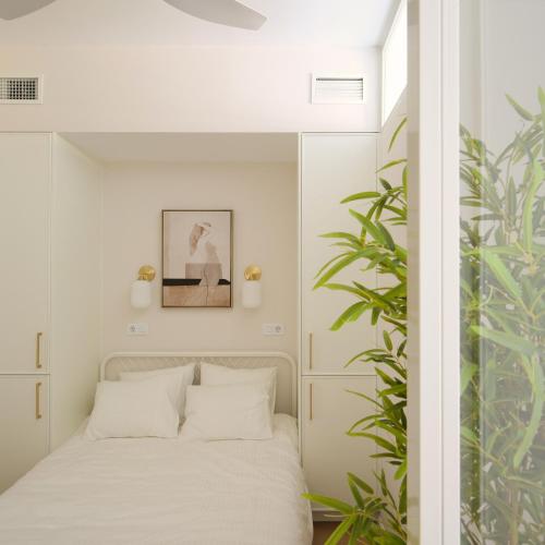 マドリードにあるSTAYLISH STUDIO APARTMENT IN MALASANAのベッドルーム1室(ベッド1台、植物付)