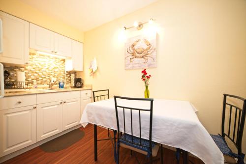 a kitchen with a table with a vase of flowers on it at Cozy Canaveral Beach Condo! Next to NASA Launch Site in Cape Canaveral