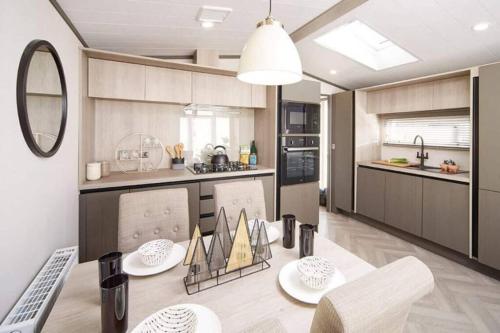 a kitchen with a table and some chairs in a room at Lowena Lodge - Padstow in Padstow