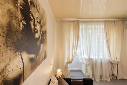 una habitación con un retrato de una mujer y una ventana en Уютная квартира на Печерске, en Kiev