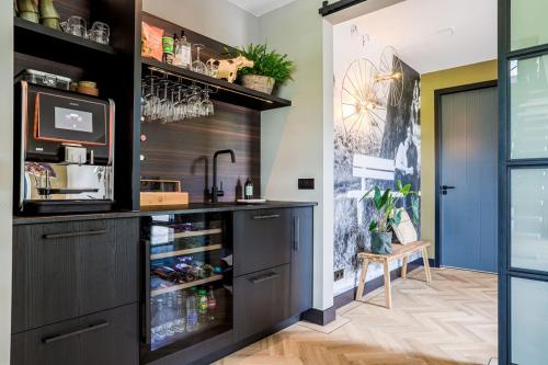 HolthoneにあるB&B De Scheersehoeveのキッチン(黒いカウンター、冷蔵庫付)